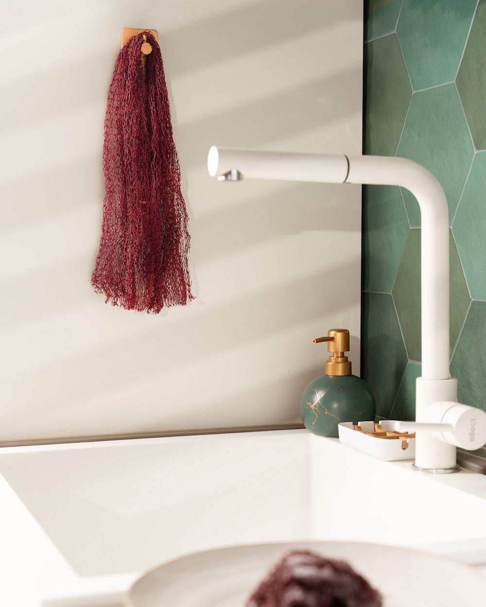 Red dry Fischnetz With Benefits hangs in kitchen next to a sink.