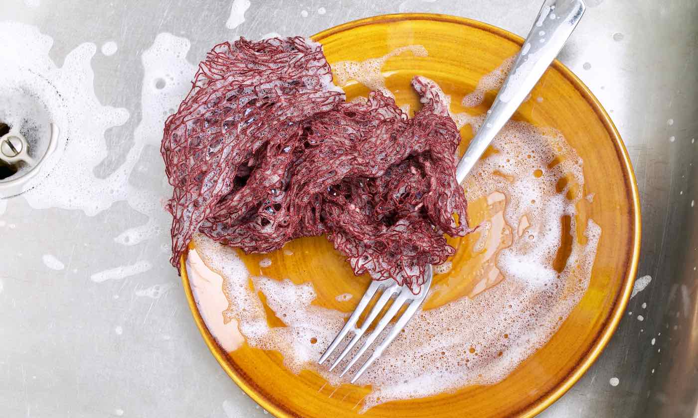 A foamyFischnetz with benefits on a brown plate. It is the best alternative for dish sponges.